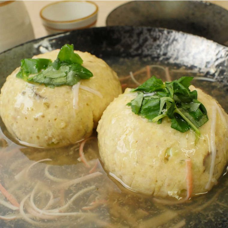 黒い皿に盛られた、あんかけ豆腐ハンバーグ