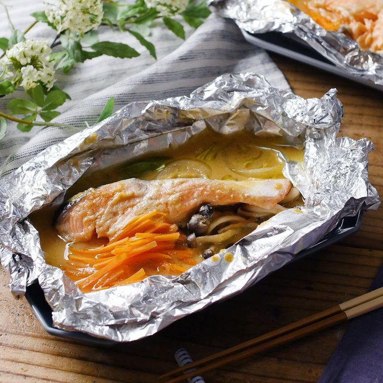 黒い皿に盛り付けられた鮭のホイル焼き