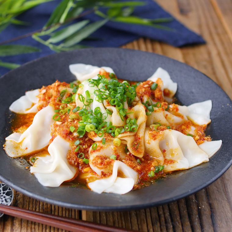 黒い皿に盛りつけられた香味ラー油だれの水餃子
