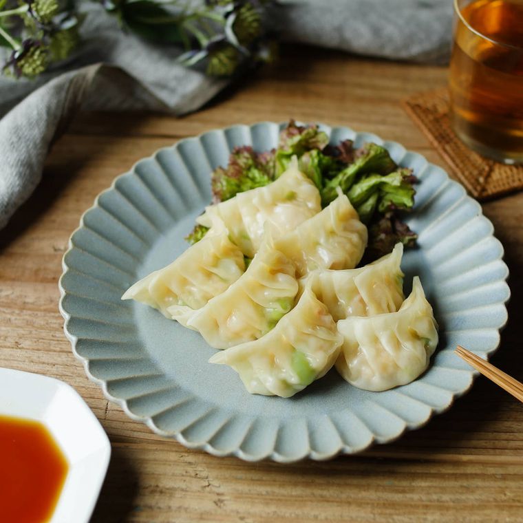 水色の皿に盛りつけられたえびと枝豆の蒸し餃子