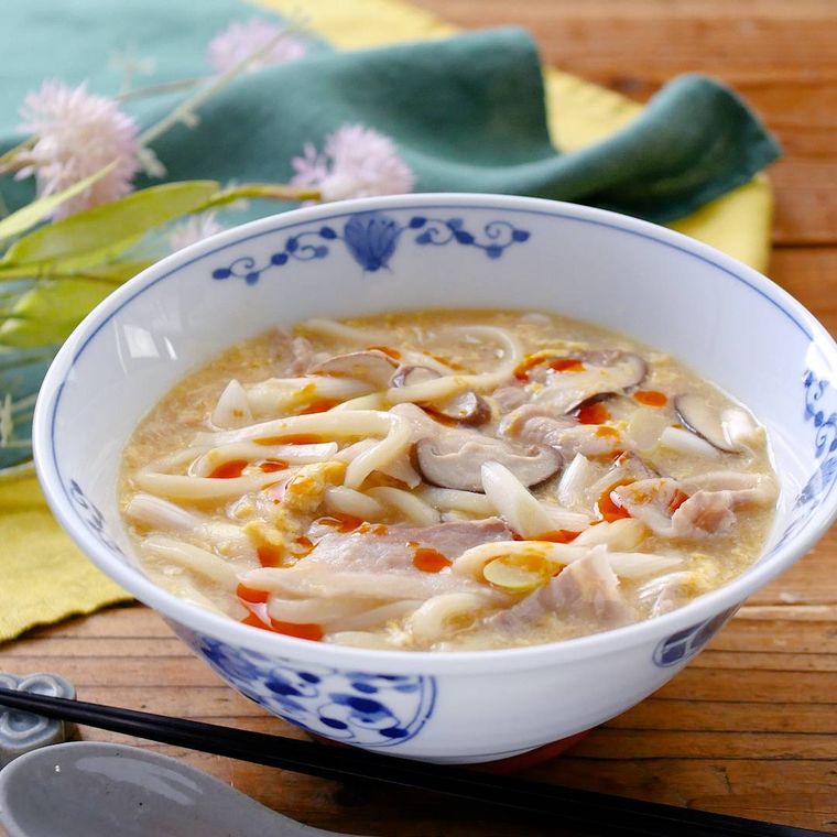 白い器に盛り付けた豚肉と長ねぎのサンラータン煮込みうどん