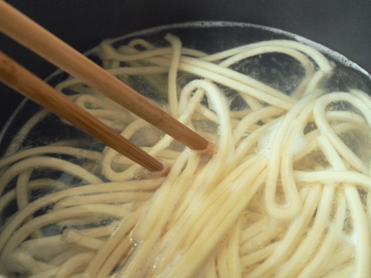 うどんの麺を箸でほぐしている様子