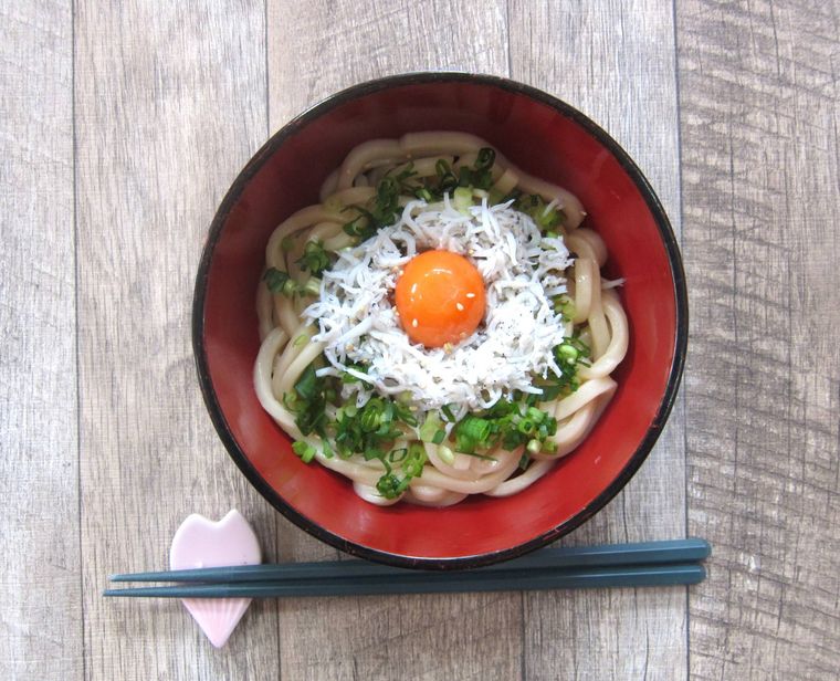 内側が赤いお椀に入れたしらすの釜玉うどん