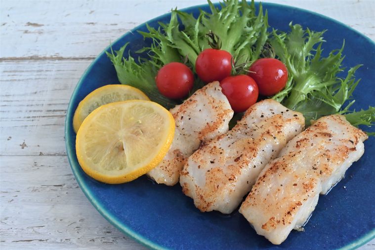 青い皿に盛られたムニエルと添えられた野菜