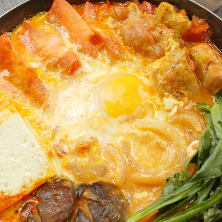 フライパンで煮込まれるモッツァレラと鶏肉のトマトすき焼き