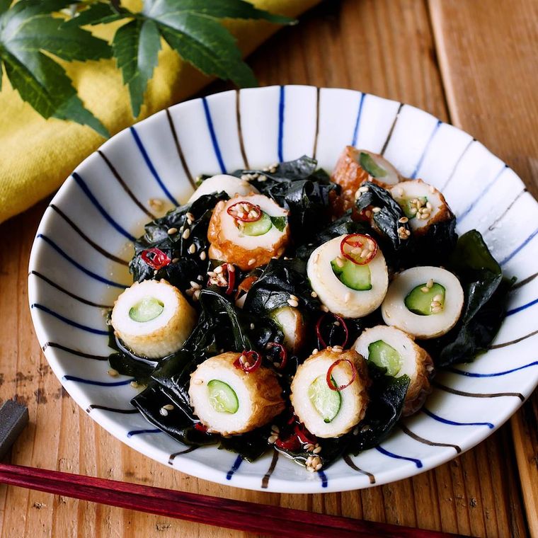 青い和風の大皿に盛り付けられている竹輪きゅうりとわかめのポン酢和え