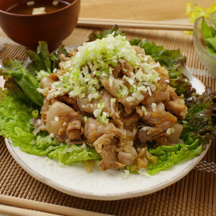 白い皿に盛られたねぎの豚バラ焦がしじょうゆ炒め