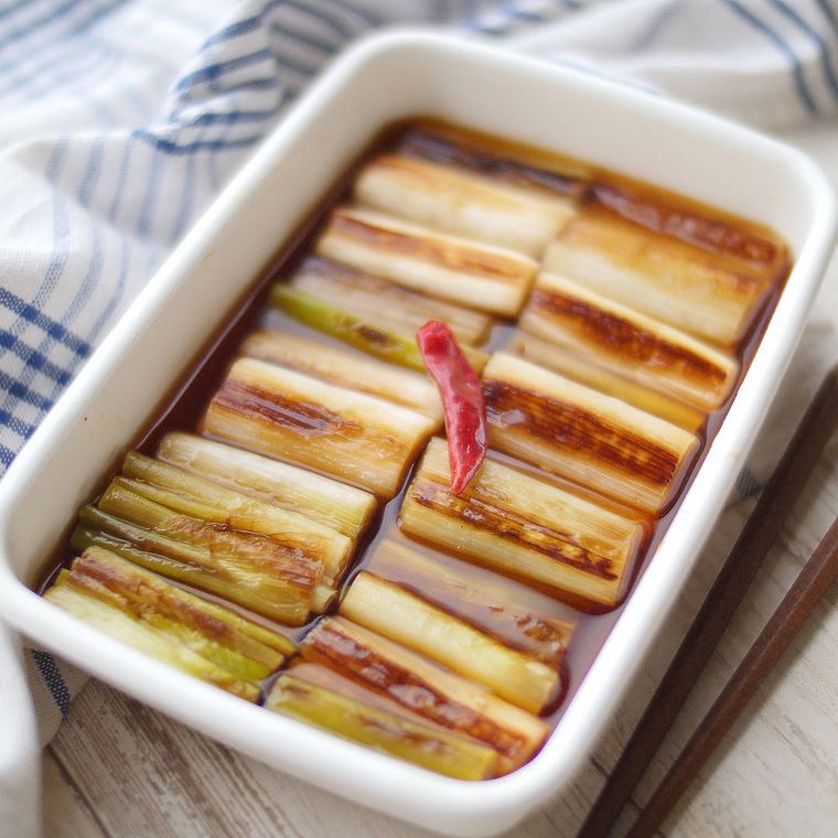 白い保存容器に入っている焼き白ねぎの香ばしおひたし