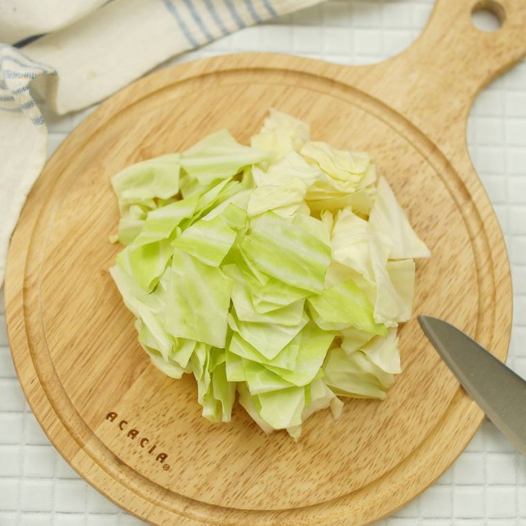 木製のまな板にのっているざく切りにしたキャベツ