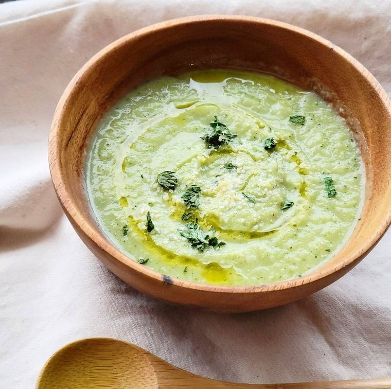 キャベツとブロッコリーのポタージュが木のカップに入っているところ