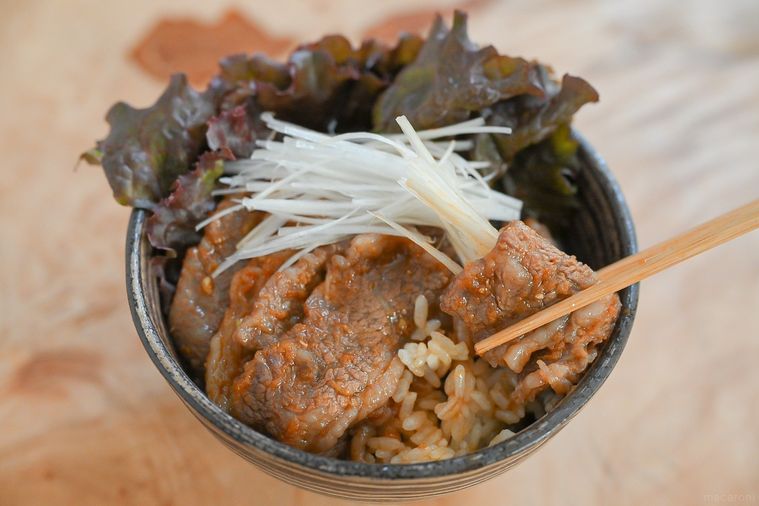 箸で持ち上げた牛カルビ丼