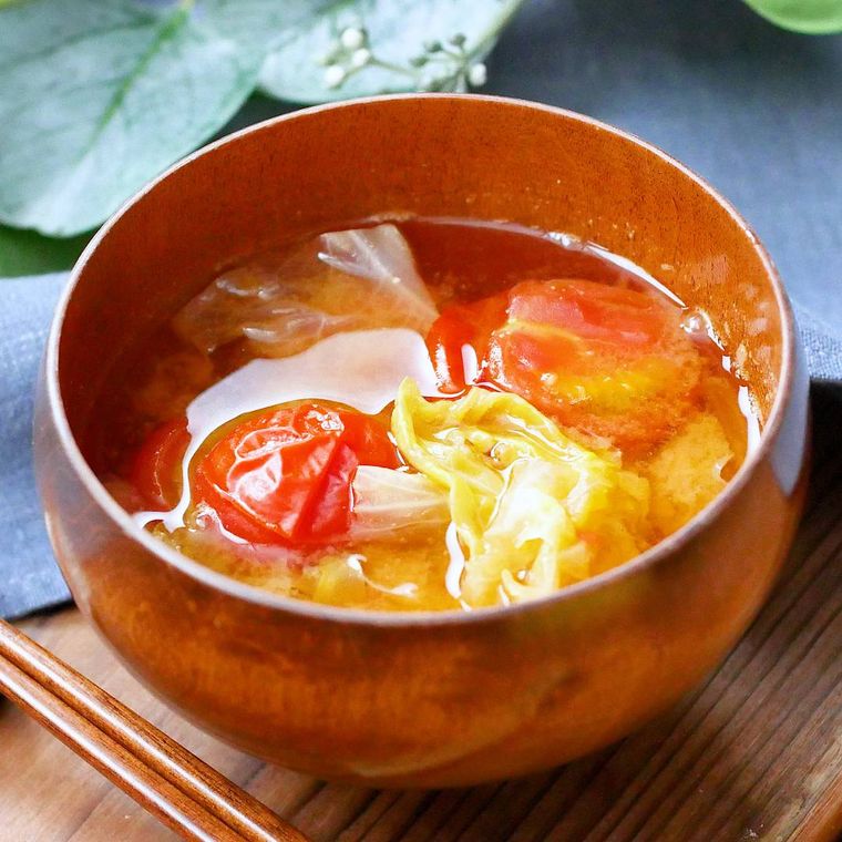 茶色いお茶碗に入ったレタスとミニトマトの味噌汁