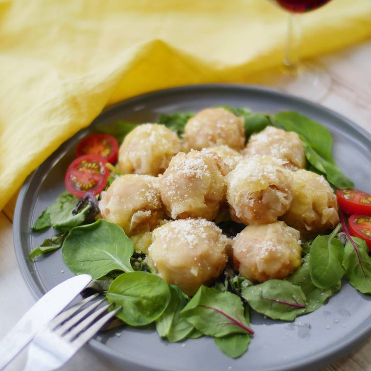 黒い皿に盛られているトマトと粉チーズの洋風しゅうまい