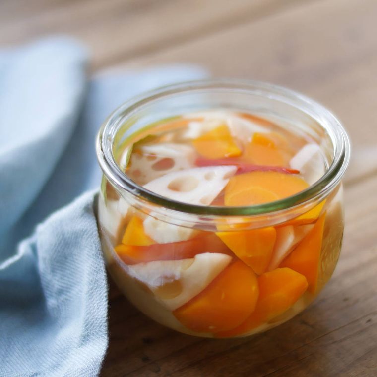 透明の容器に入ったれんこんとにんじんのピクルス