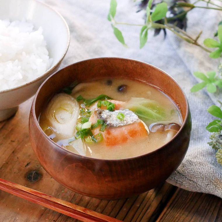 木のお椀に盛りつけられた鮭とじゃがいも、キャベツ入り味噌汁