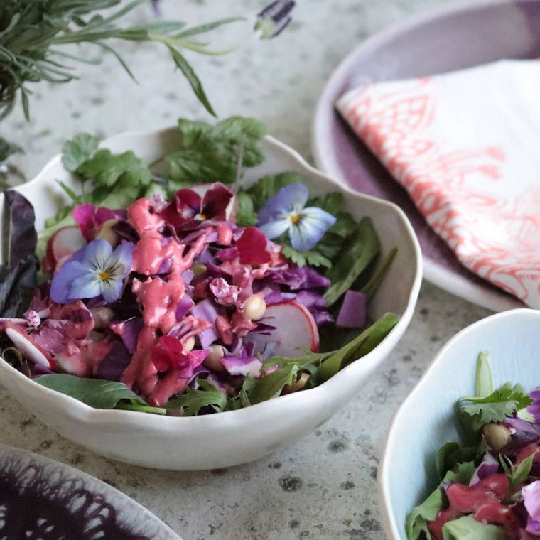 白い深鉢に盛りつけられたハーブや大豆、ベビーリーフのサラダ