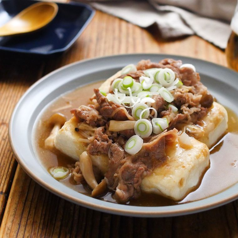 白い皿に盛り付けた薄切り牛肉のあんかけ肉豆腐