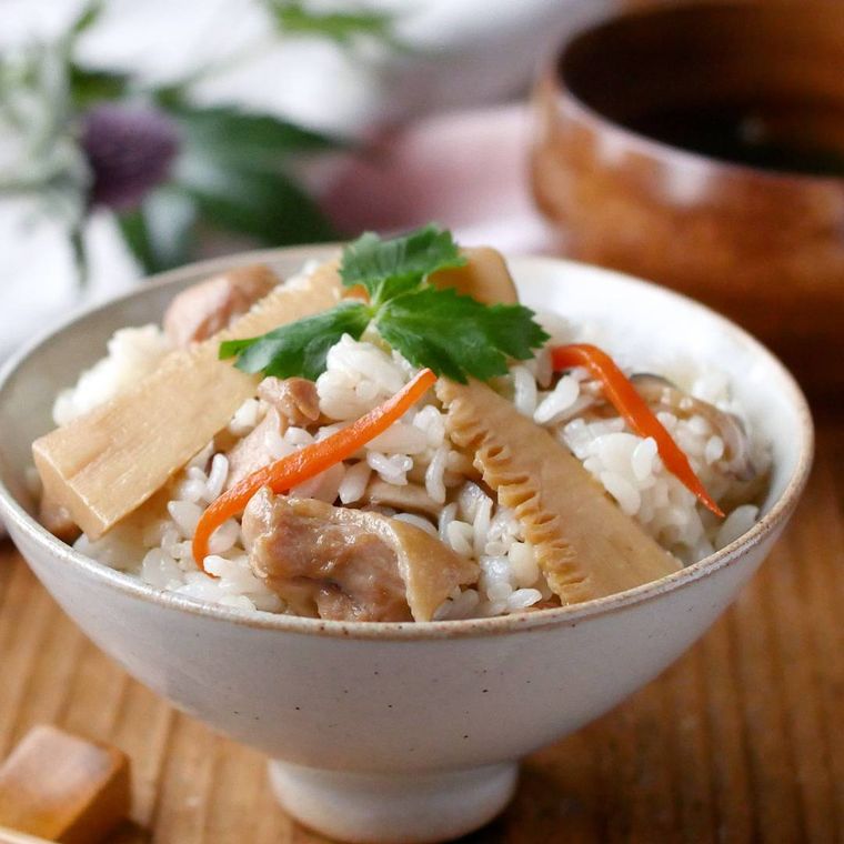 ベージュのお茶碗に盛られた鶏肉とたけのこの混ぜ込みごはん