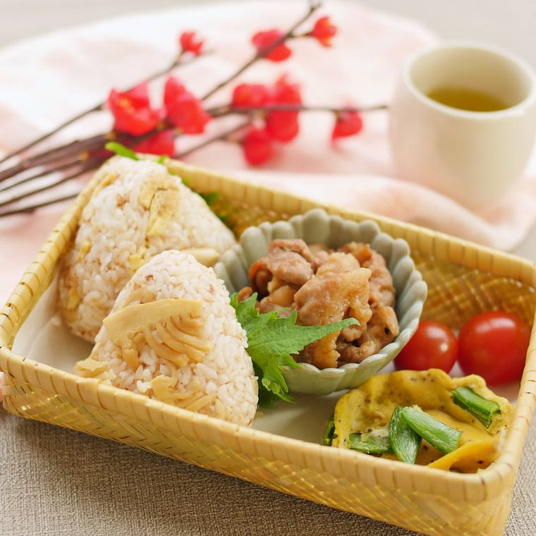 お弁当箱にたけのこおにぎりが入っている様子