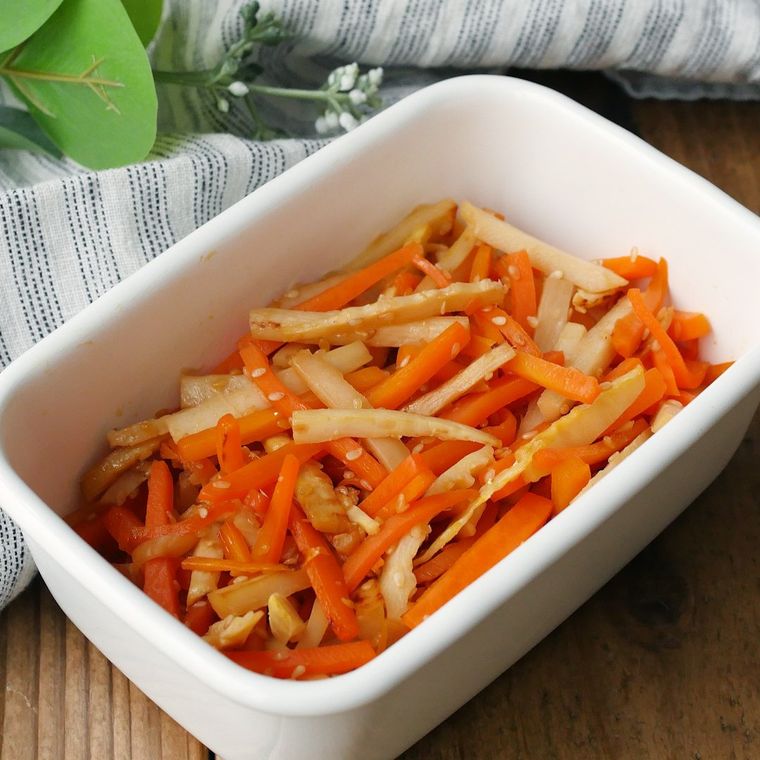 白い保存容器に入っているたけのことにんじんのきんぴら