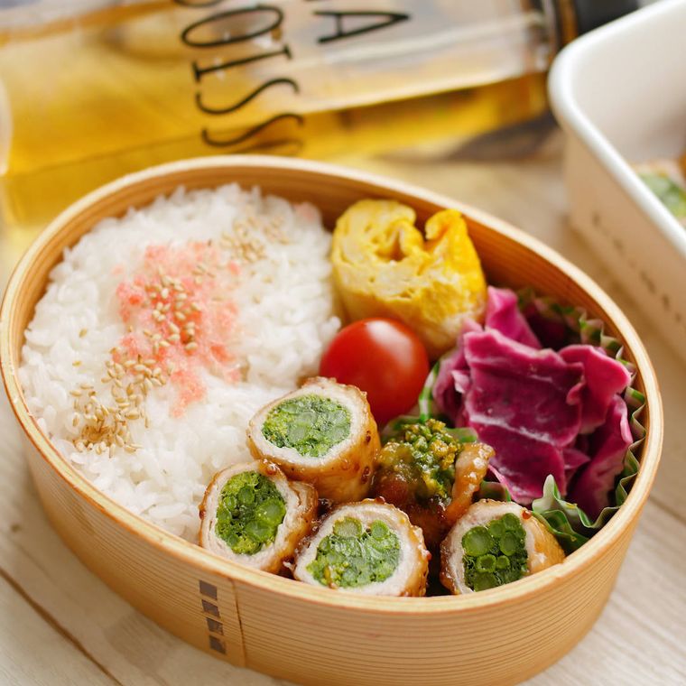 弁当箱に詰めた菜の花のてりやきマスタード肉巻き