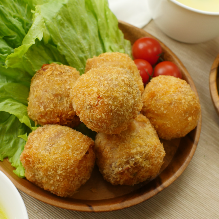 木の皿に盛り付けたピリ辛豚キムチーズライスコロッケ