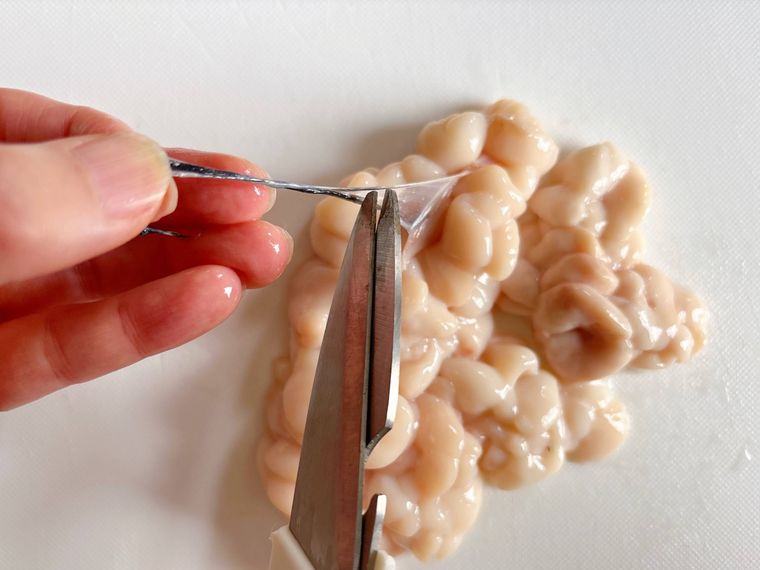 白子の筋と血管をキッチンバサミで取り除く様子