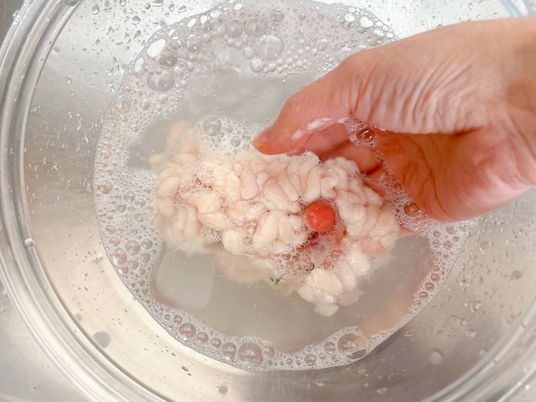 水で白子の汚れと塩分を洗い流す様子