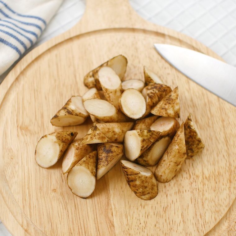 丸いカッティングボードの上で乱切りされたごぼう