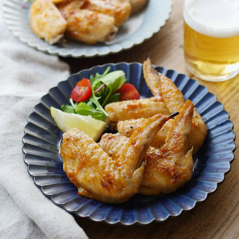 青い皿に盛られた鶏手羽先のトムヤム焼き