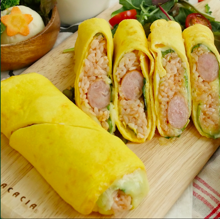 木のトレイに並べたソーセージ入りスティックオムライス