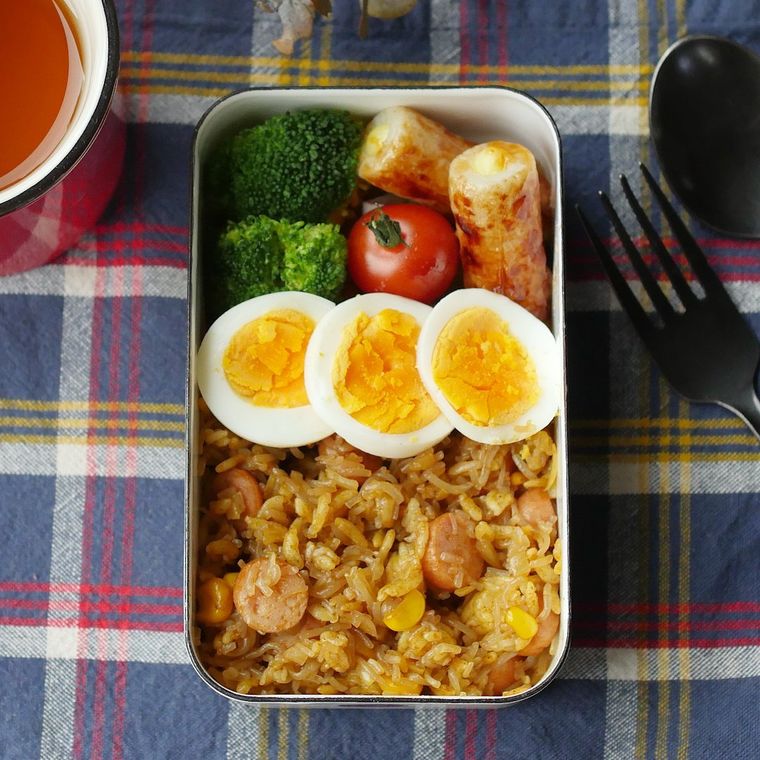 四角いランチボックスに入ったソーセージのカレーピラフ風弁当