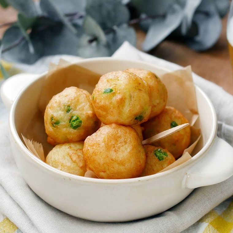 両手つき丸いグラタン皿に盛りつけられた新じゃがいもとはんぺんのふんわり揚げ