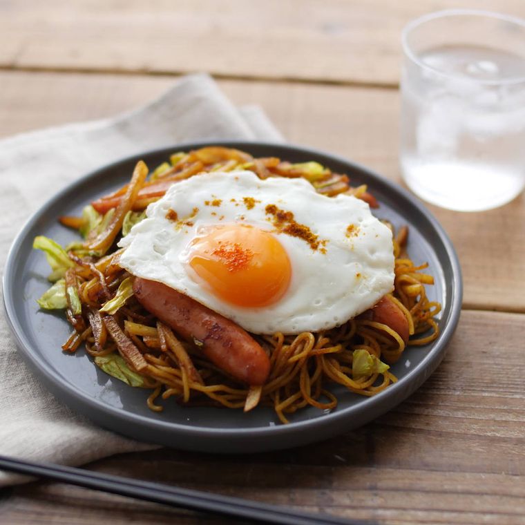 黒い皿に盛られたカレー風味の焼きそば