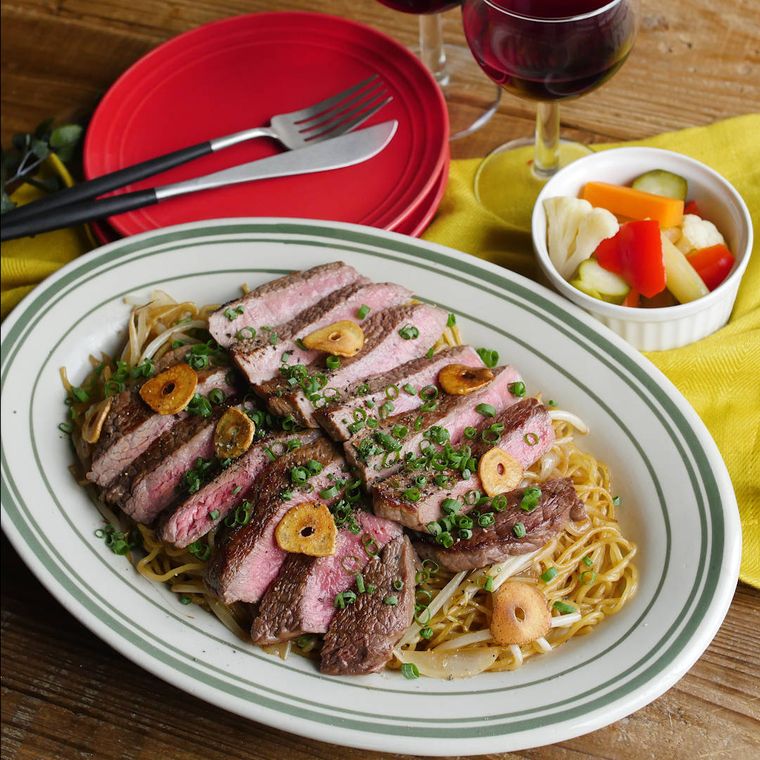 白い楕円皿に盛り付けたガーリックステーキのっけ焼きそば