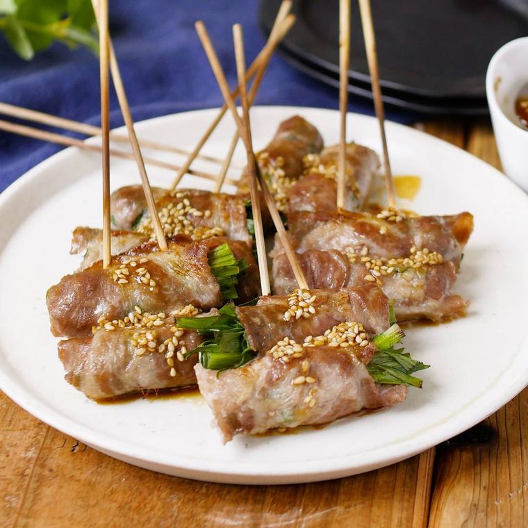 ニラ豚串が白い皿に盛り付けられているところ