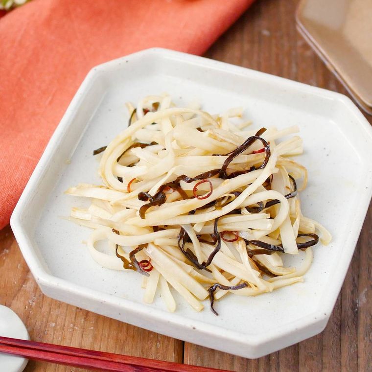 白い八角皿に盛りつけられた大根の皮の塩こんぶきんぴら