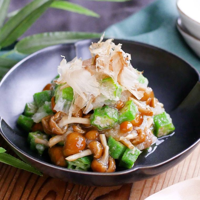 黒い皿に盛り付けたオクラとなめこのさっぱりおろし和え