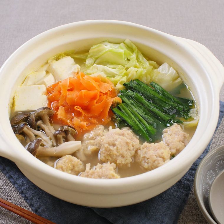 白い土鍋に入っている塩ベースの鶏つみれ鍋