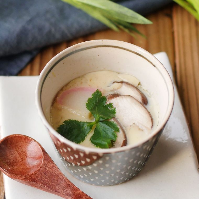 幾何学模様の器に入っているえびとかまぼこ、しいたけの茶碗蒸し