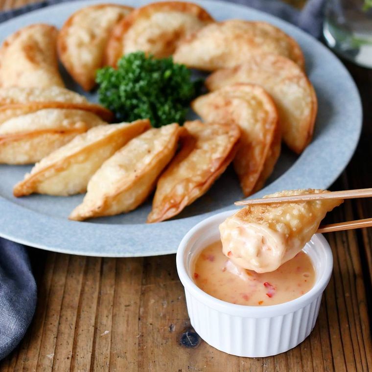えびとはんぺん入りの揚げ餃子をチリマヨソースにつけている様子