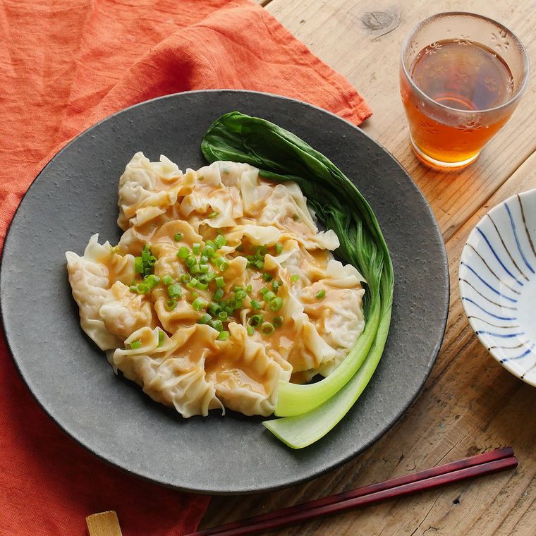 グレー色の皿に盛りつけられたえびワンタンのピリ辛ごまだれがけ