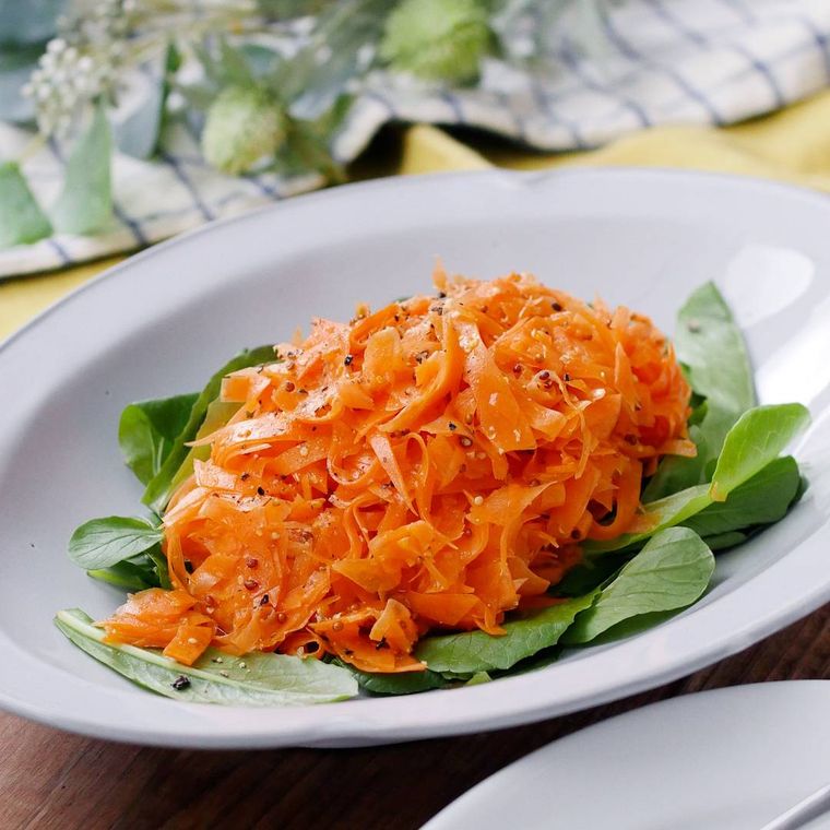 白い楕円の皿に盛られたにんじんのシャキシャキサラダ