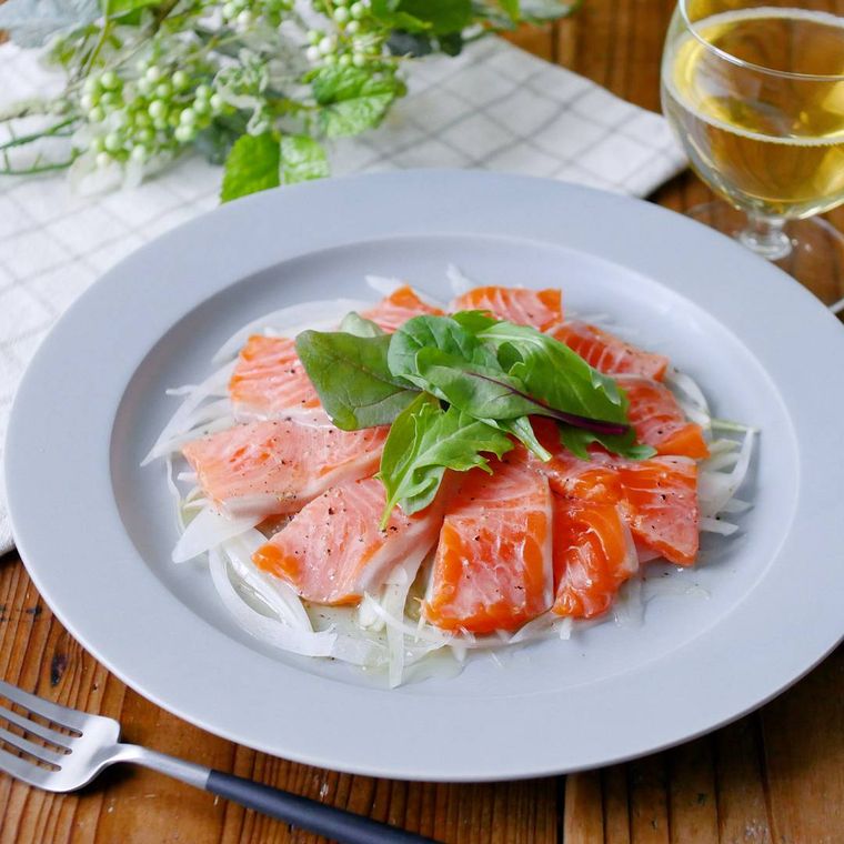 グレーの皿に盛られたサーモンのカルパッチョ