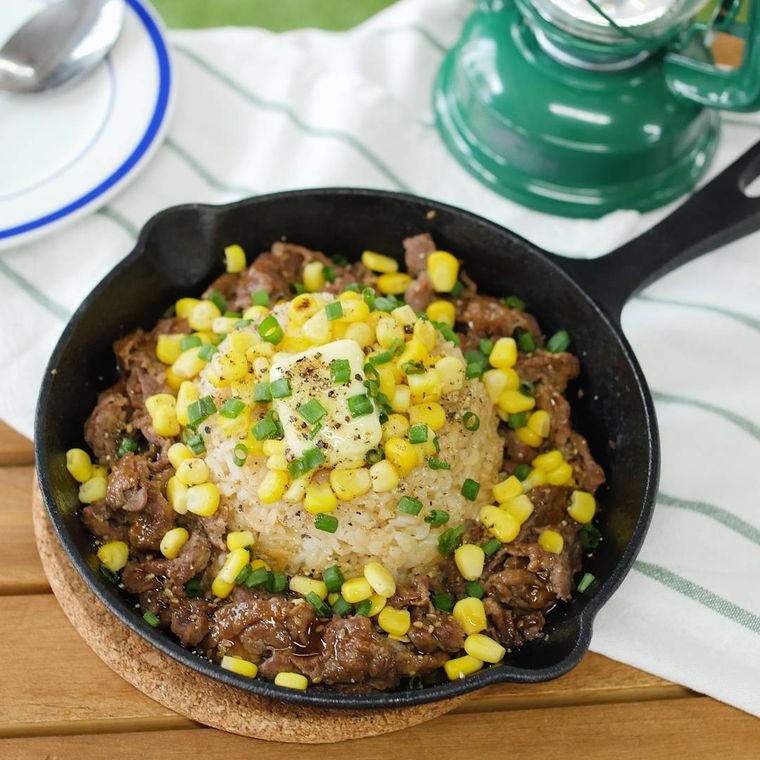 スキレットに盛りつけられた牛バラ肉とコーン入りのバターライス