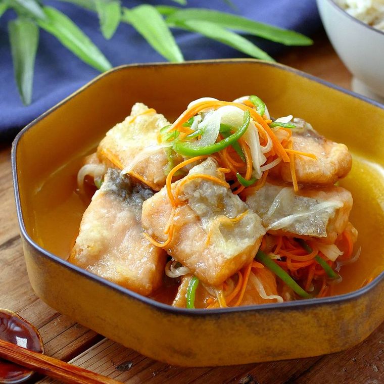 オレンジ色の器に盛りつけられた鮭の南蛮漬け