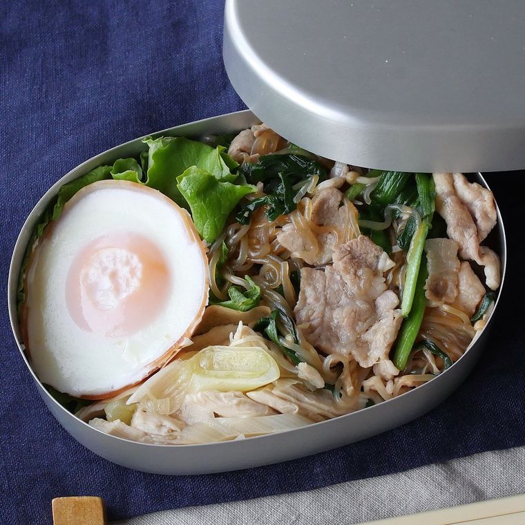 お弁当箱に入った糸こんにゃくの中華風焼きそばと鶏ささみの和え物と目玉焼き