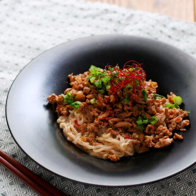 黒い皿に盛り付けられた、糸こんにゃくの汁なし担々麺