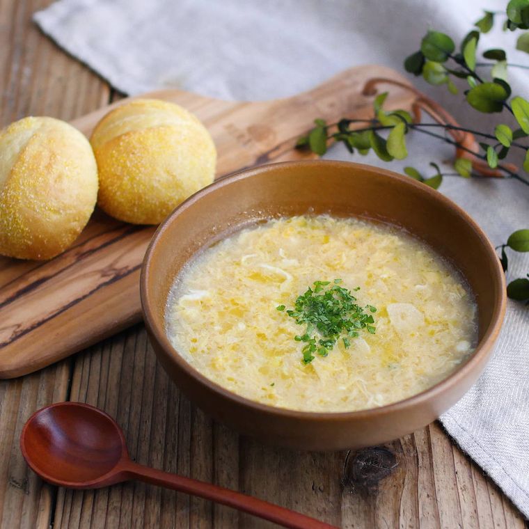 木の器に入ったふわふわ卵のスープと丸パン