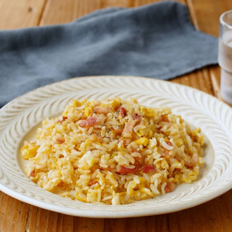 白い皿に盛りつけられたベーコンとねぎの卵チャーハン